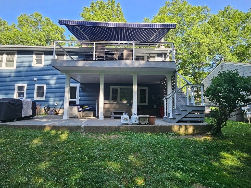 Full view of the elevated composite deck, upper awning, and sheltered lower-level living area.